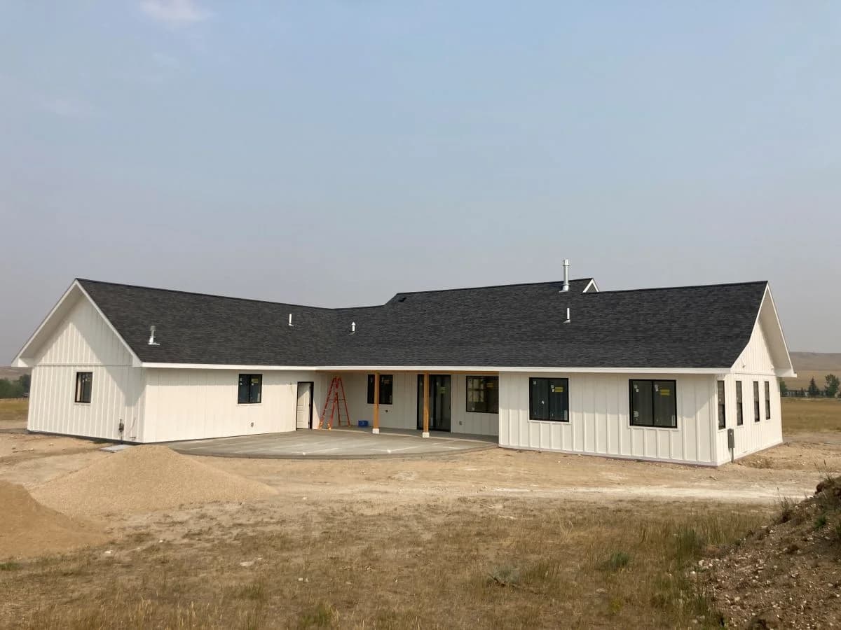 Completed modern farmhouse custom home with white board and batten siding built by Buffalo Built LLC in Wyoming.