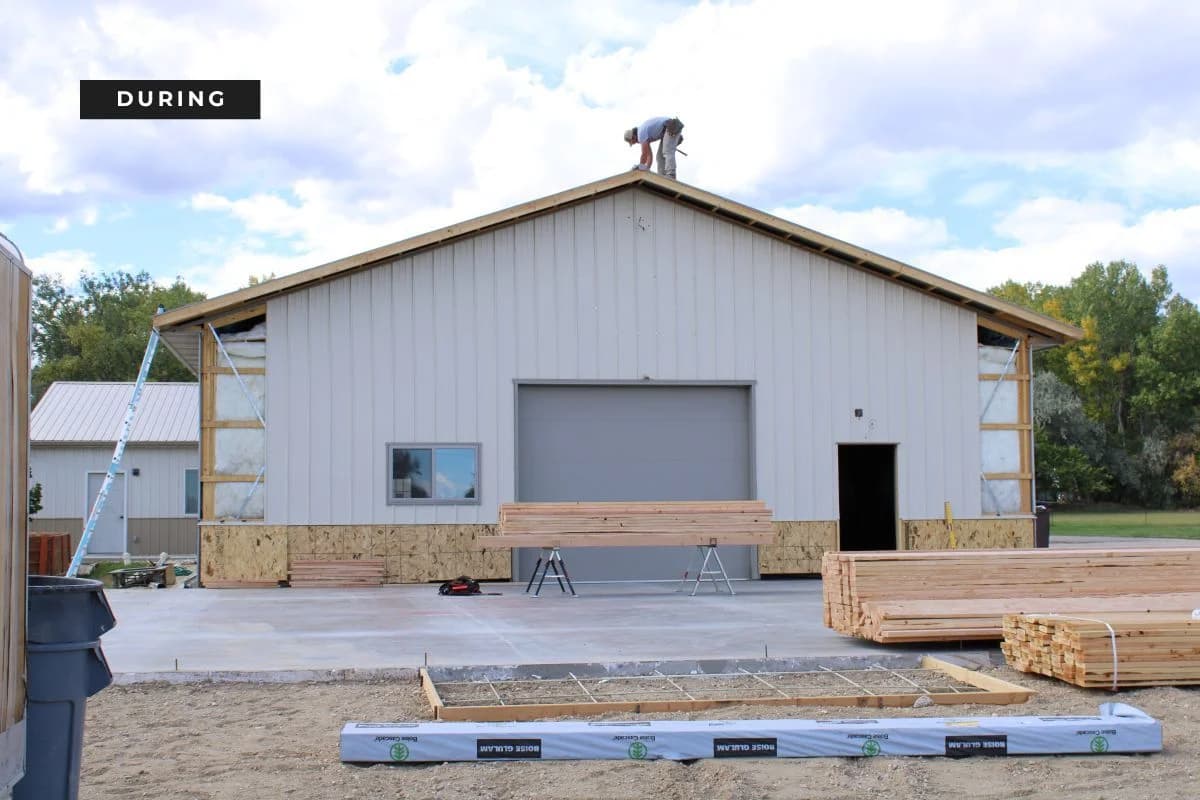 Active roofing and metal siding installation phase during the construction of the Trailhead Student Ministry building by Buffalo Built LLC.