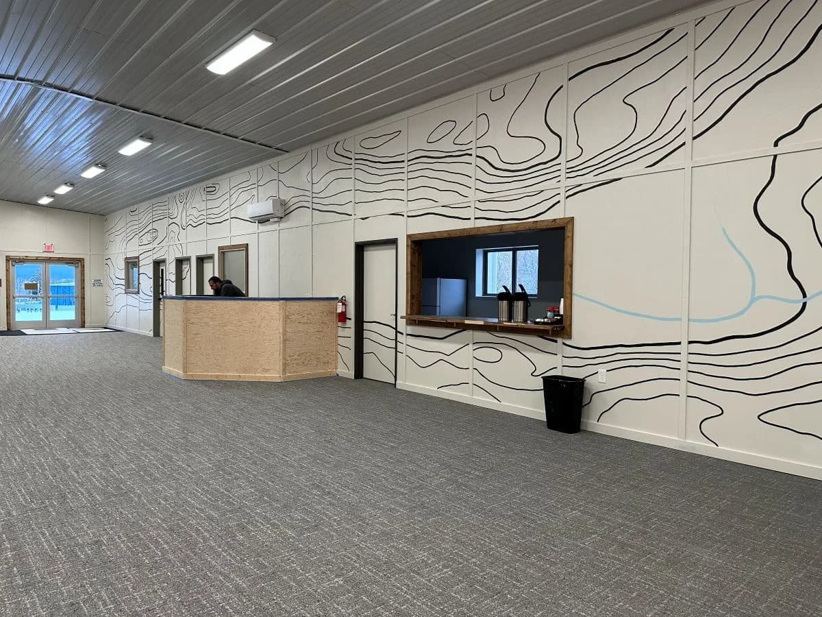 Completed commercial interior build out for Trailhead Student Ministry featuring custom service window and topographic wall mural by Buffalo Built LLC.