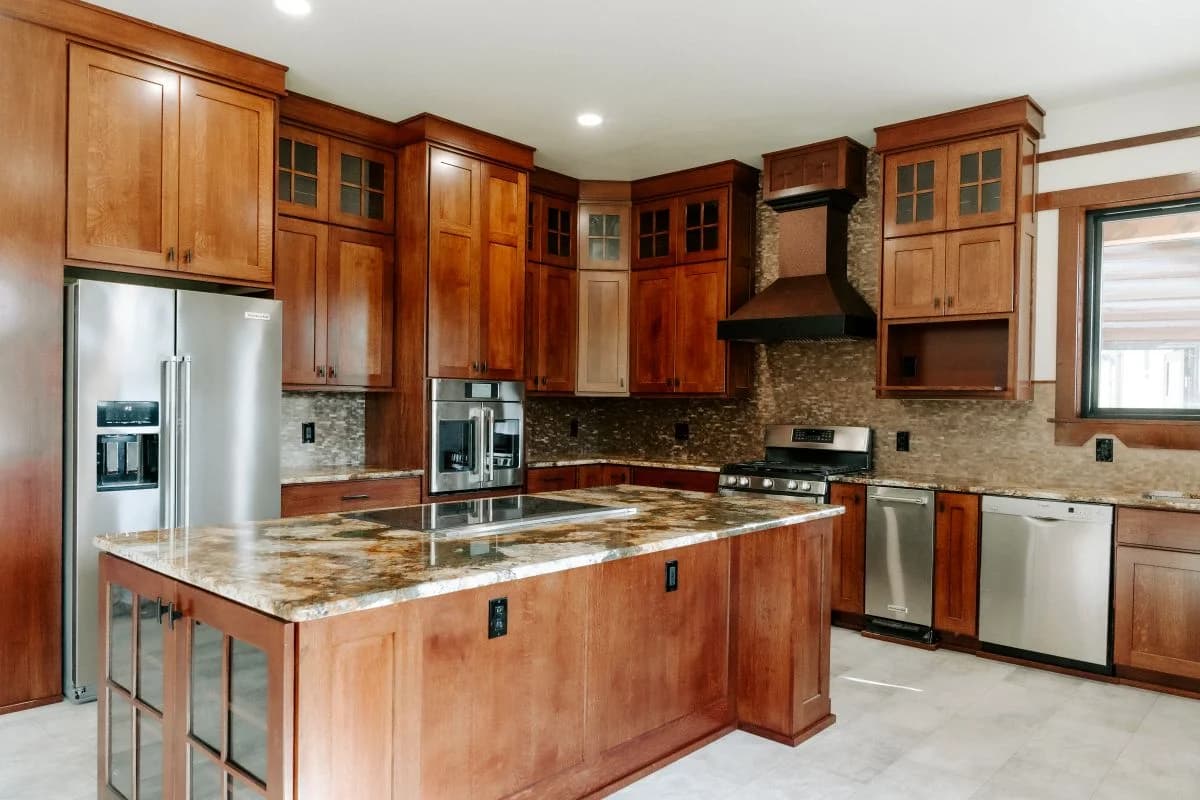 Luxury custom kitchen design featuring rich wood cabinetry and an expansive granite island by Buffalo Built LLC in Buffalo, WY.