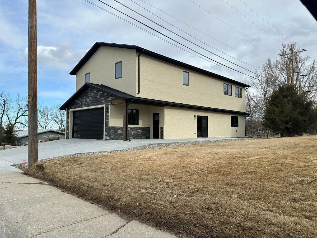 Completed design build modern two story custom home with stucco and stone veneer finishes by Buffalo Built LLC in Buffalo, WY.