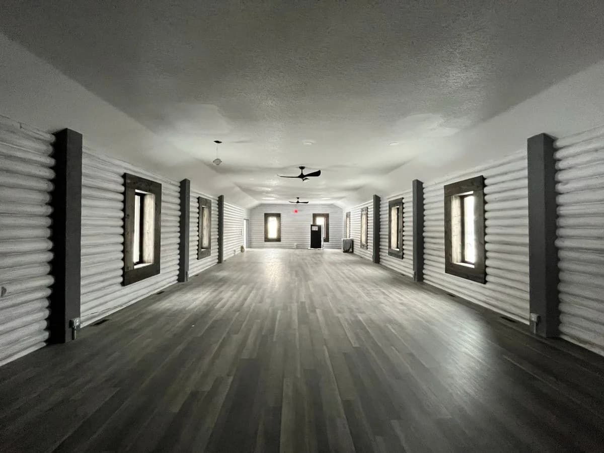Completed interior renovation showcasing modern white log walls and dark trimmed windows by Buffalo Built LLC.