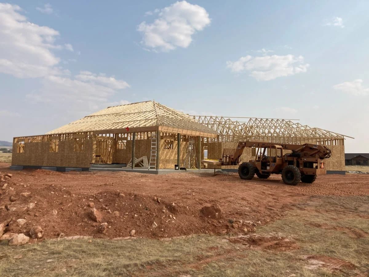 Active custom home framing phase showcasing an extensive roof truss system layout by Buffalo Built LLC.