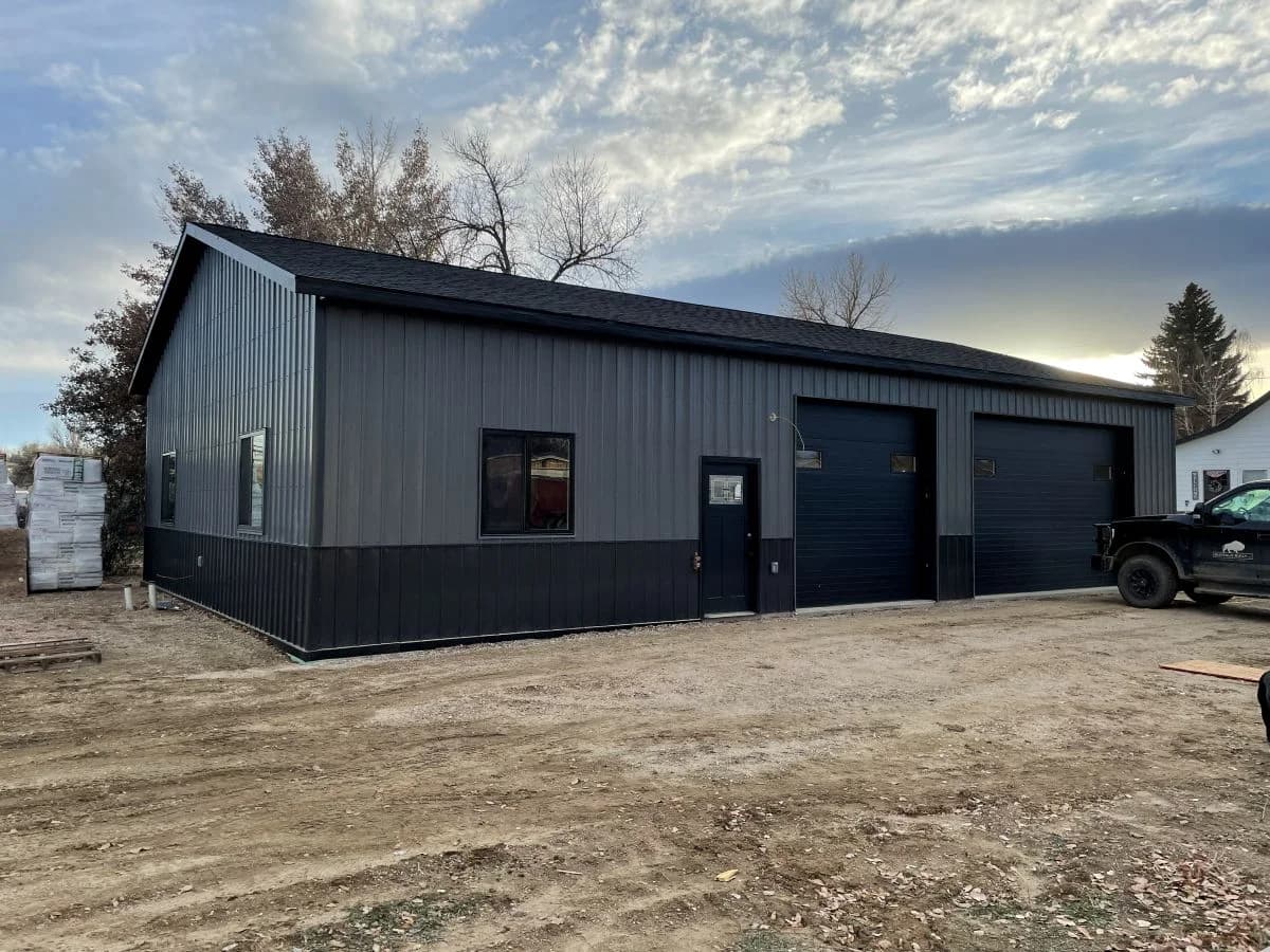 Completed custom multi-bay garage and metal shop building showcasing two-tone siding by Buffalo Built LLC.
