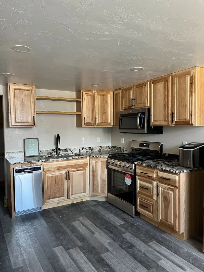 Modern rustic kitchen remodel featuring custom natural wood cabinets and granite countertops by Buffalo Built LLC.